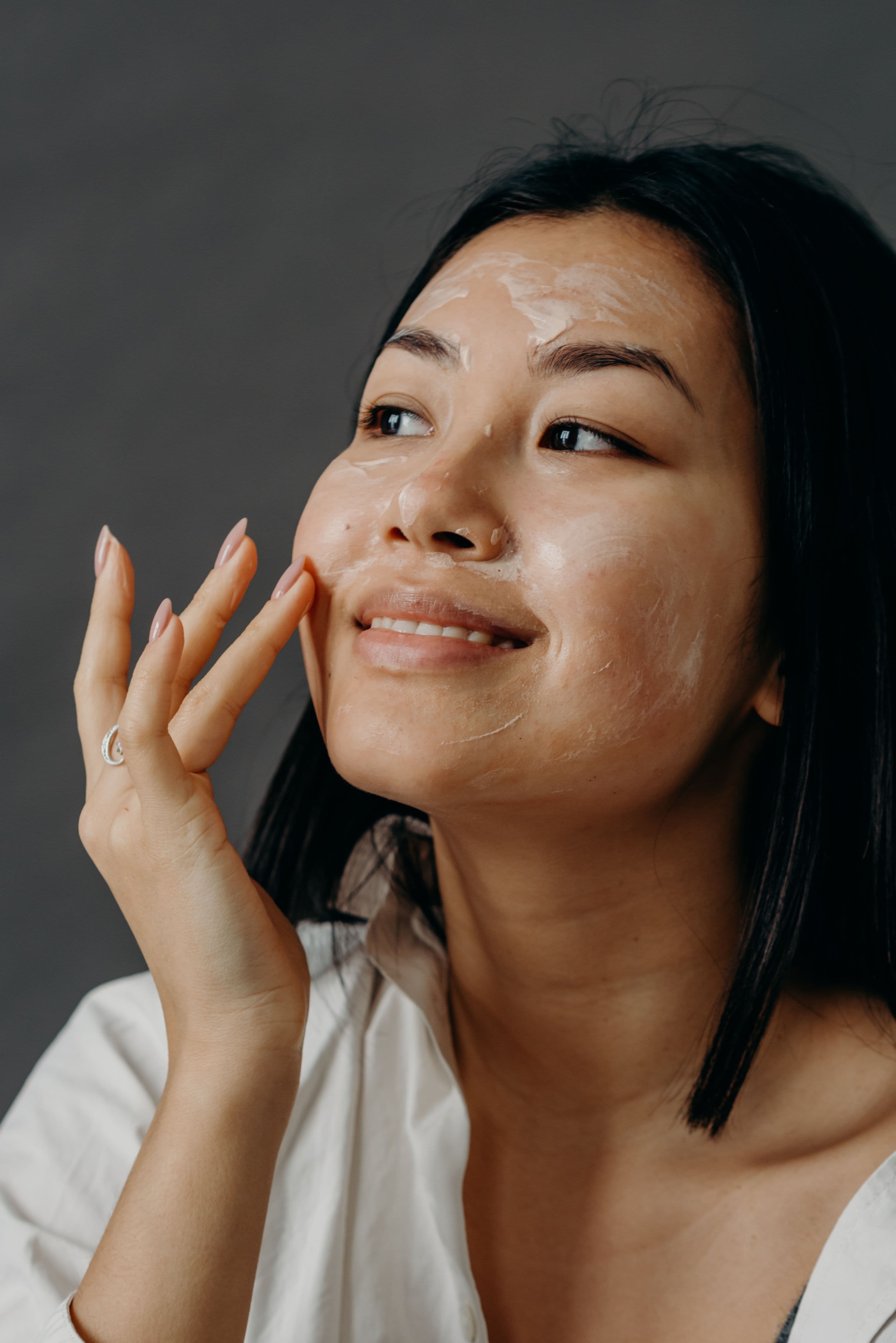 Woman applying cream to her face.