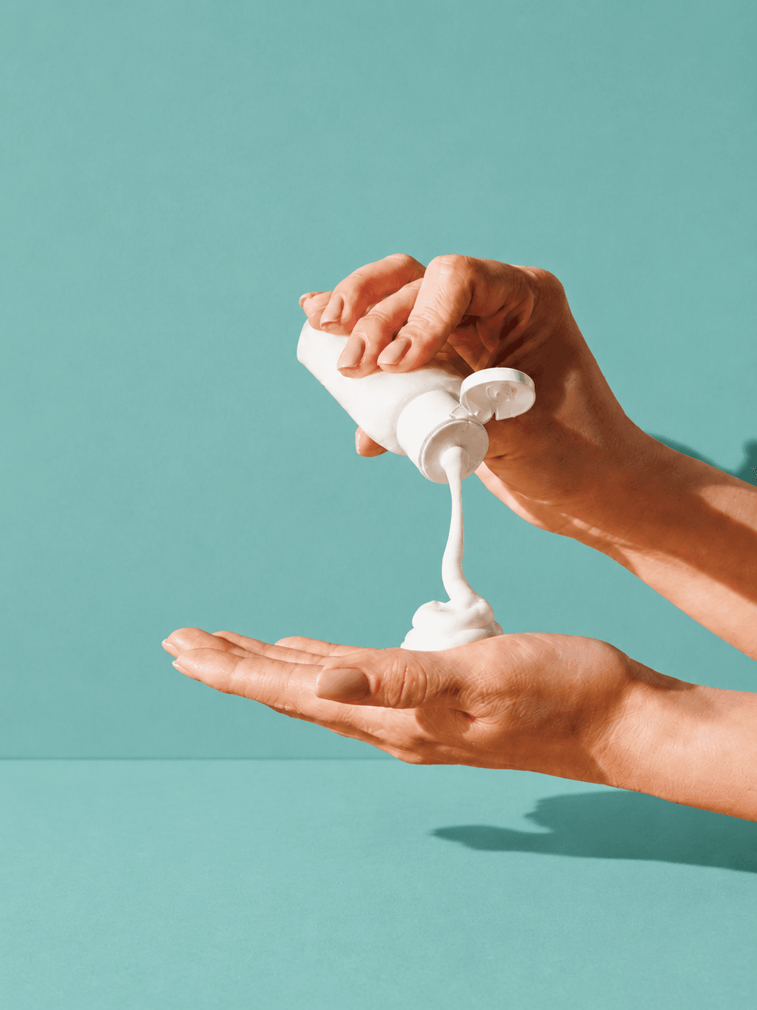 Close-up of hands applying a thick moisturizing ointment as part of the dermatologist-recommended soak and smear technique for dry, cracked, or eczema-prone skin.