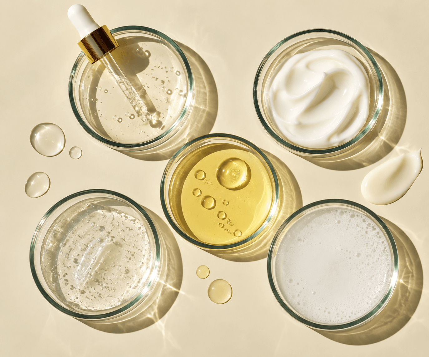 Five glass dishes holding different types of skincare formulas.