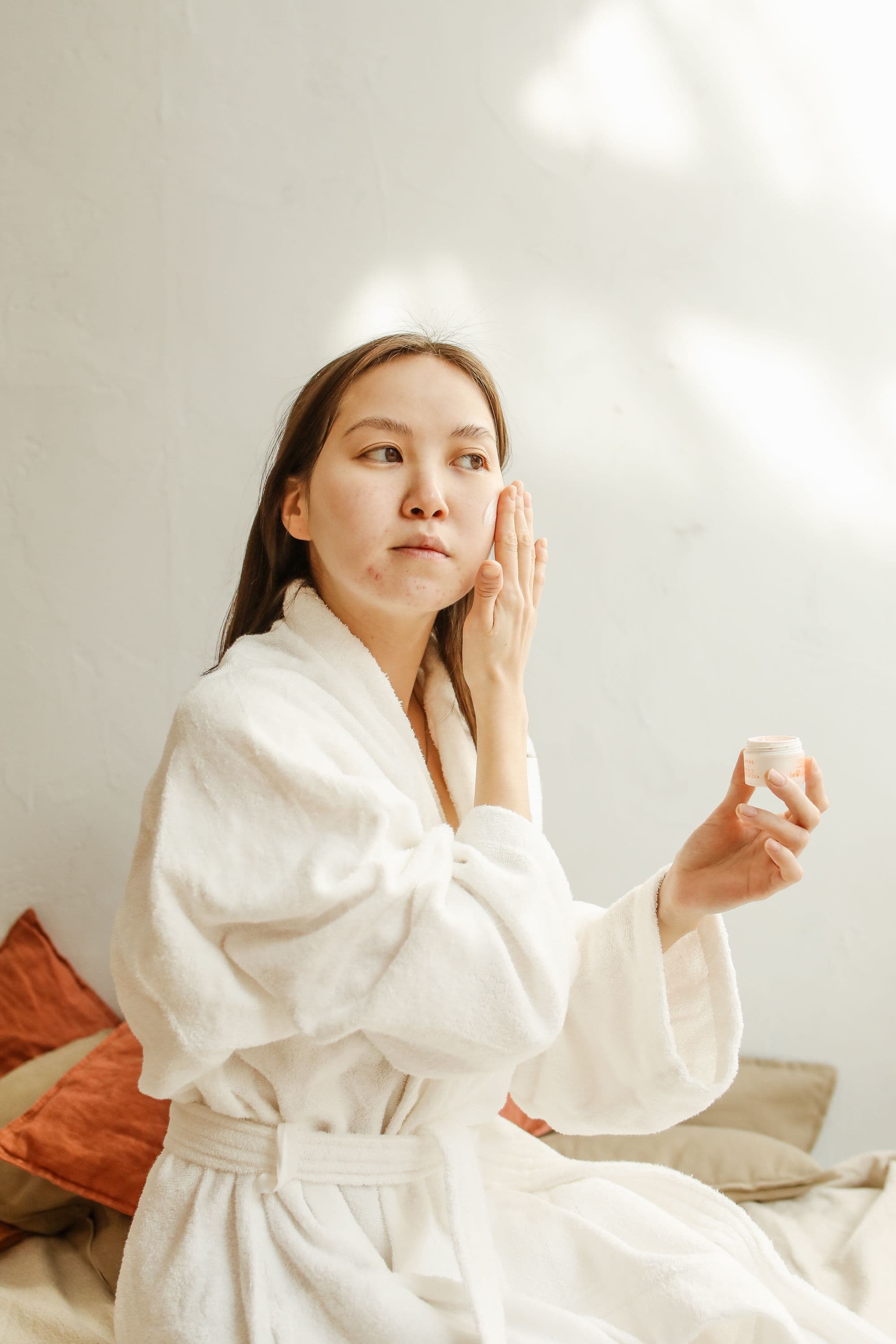 A destressed looking woman touching her face.