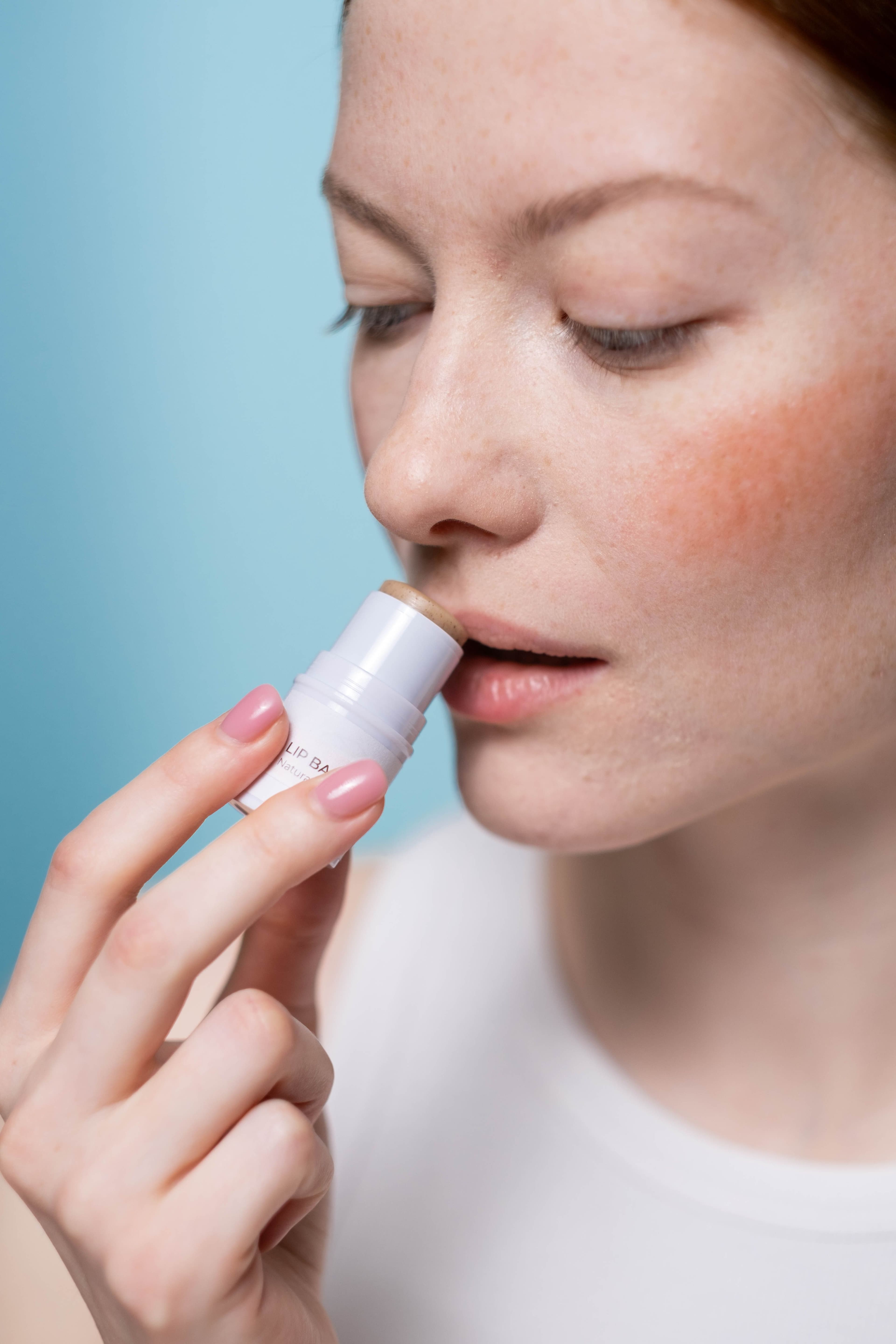 Woman applying lip balm.